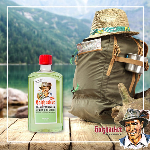 Holzhacker Franzbranntwein Arnika & Menthol Flasche (Kunststoff) mit Rucksack vor einem Bergsee | Naturpräparate Dieterich